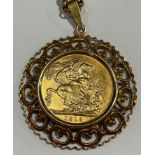 A full sovereign, 1918, mounted in a 9ct gold mount; a base metal rolo link chain