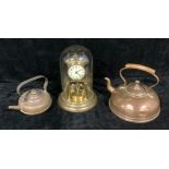 A brass anniversary clock, glass dome, 27cm; a copper kettle; another smaller (3)