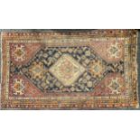 An antique Oriental rug, 227cm x 132cm