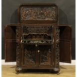 A Southeast Asian cocktail cabinet, carved throughout in the traditional manner, 106cm high, 96cm