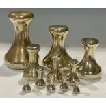 A set of eleven graduated brass capstan weights, from 7lb to half and ounce, the tallest 13cm