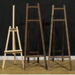 A floor standing artist's easel, 183cm high; another similar; a smaller easel (3)