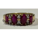 An 18ct gold ruby and diamond ring, set with four graduated faceted oval rubies, divided by six