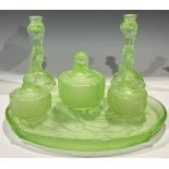An Art Deco uranium pressed glass six piece dressing table set, moulded with mermaids and shells,