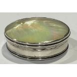 An 18th century silver coloured metal and mother of pearl circular snuff box