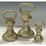 A set of three graduated brass bell weights, 7lb, 4lb and 1lb