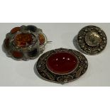 A Scottish silver and agate brooch; a thistle brooch; an oval agate set brooch (3)