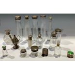 A collection of late 19th century and later glass vanity jars and bottles, some with silver tops,