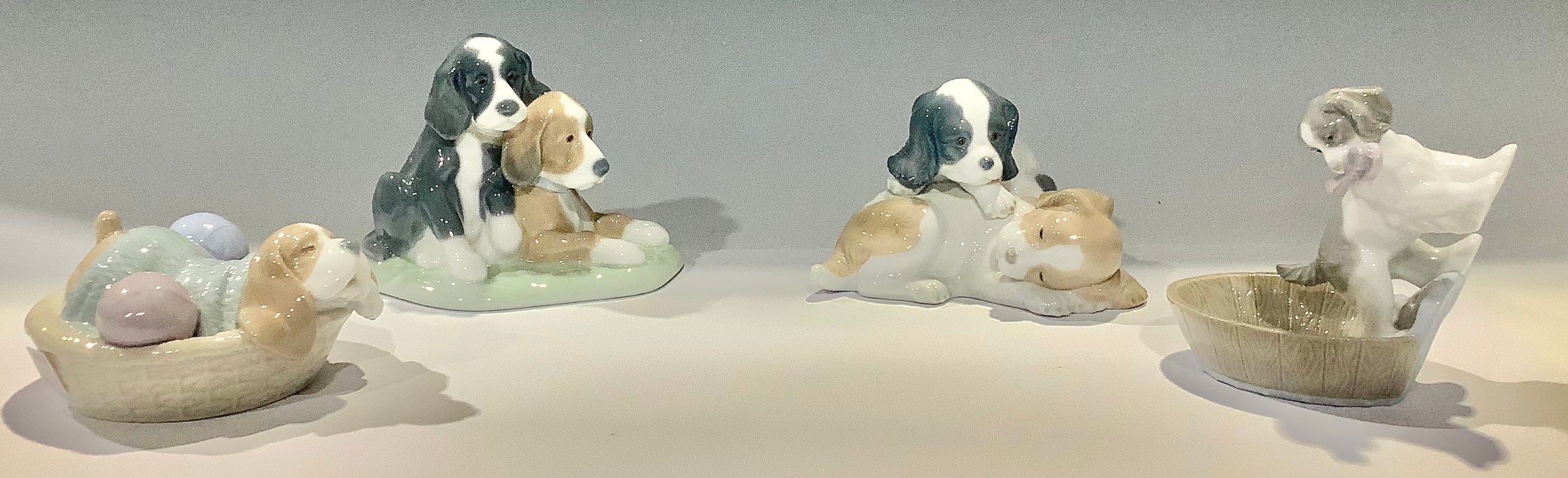 A Nao model group, puppies resting, three others similar (4)