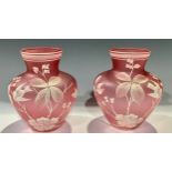 A pair of Stourbridge type pink opaque glass shoulder vases, painted in white enamel with birds