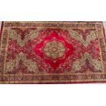 A large Middle Eastern woollen rug or carpet, central medallion within a field of scrolling