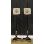 A near pair of William IV parcel-gilt simulated rosewood pole screens, the largest 147cm high, the