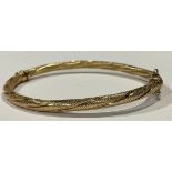 A 9ct gold hinged bangle, spirally fluted, marked 375, 5.19g