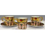 A pair of Royal Crown Derby 1128 Imari pattern coffee cans and stands, solid gold band, first