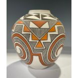 An ovoid Acoma vase, by R Patricio, signed, typically hand decorated with geometric shapes in