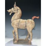 A Chinese Tang style terracotta horse, in muted shades of ochre and red, 50cm