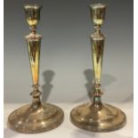 A pair of Sheffield plate candlesticks and nozzles, of circular form with reeded borders, one