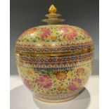An Indonesian ovoid jar and domed cover, spire finial, printed and painted with pink and red