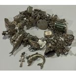 A sterling silver curb link charm bracelet, assorted charms including rooster, reticulated fish,