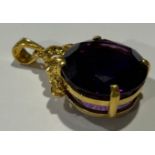 A gold coloured metal mounted Amethyst pendant, the large circular single stone facet cut, claw set,