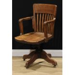An early 20th century oak swivel desk chair, 92.5cm high, 57cm wide, the seat 47.5cm wide and 44.5cm