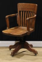 An early 20th century oak swivel desk chair, 92.5cm high, 57cm wide, the seat 47.5cm wide and 44.5cm