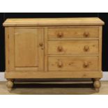 A Victorian pine low dresser, of three drawers neighboured by a panel door, enclosing a shelf,