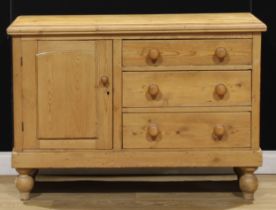 A Victorian pine low dresser, of three drawers neighboured by a panel door, enclosing a shelf,