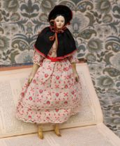 A mid 19th century painted papier-mâché shoulder head doll, the papier-mâché head with black moulded