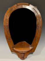 An early 20th century horseshoe shaped walnut looking glass, bevelled mirror plate, with single