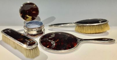 A George V silver, tortoiseshell and pique work four piece dressing table set, Birmingham 1916