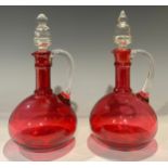 A pair of late 19th century cranberry glass decanters, clear glass stoppers, 25cm