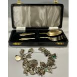 A silver christening fork and spoon set, Birmingham 1958, 36g, cased; a silver curb link charm