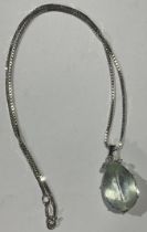 An 18ct white gold necklace, the pendant set with a pear cut aquamarine stone, accented with three