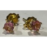 A pair of gold coloured metal ear studs set with brilliant cut pink stones, stamped '750' for 18ct