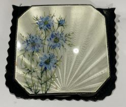 A silver and engine turned white enamel canted square compact, decorated with cornflowers, hinged