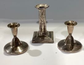 A pair of silver boudoir candlesticks, Birmingham 1957, 8.5cm high; another candlestick, Sheffield