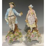 A pair of Sitzendorf figures, gallant and maiden, floral encrusted domed scroll bases, 33cm,