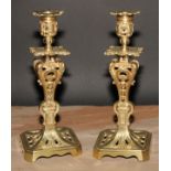 A pair of French gilt brass table candlesticks, cast throughout with scrolls and acanthus, canted