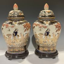 A pair of Japanese export ware ovoid vases and covers, oval wooden stands, 44cm overall