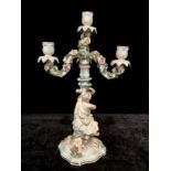 A Dresden figural three branch floral encrusted candelabra, the figural support with allegory of