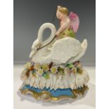 A 19th century German porcelain box and cover, Cupid riding a swan, on an oval bed of flowers,