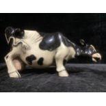 A large Continental pottery model, of a cow, marked SM, 42cm long