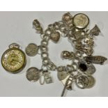 A silver charm bracelet, London 1979, various silver and other charms, 70.5g gross; a lady's fob