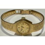 A lady's 9ct gold Accurist watch, gilt dial with baton indicators, integral 9ct gold textured bark