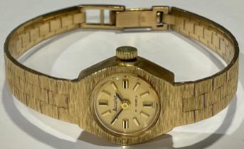 A lady's 9ct gold Accurist watch, gilt dial with baton indicators, integral 9ct gold textured bark