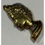 A large gold coloured metal brooch embossed as a female bust after the antique with Etruscan style