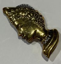 A large gold coloured metal brooch embossed as a female bust after the antique with Etruscan style