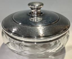 A George V silver and clear glass powder bowl the domed silver cover engine turned, 11cm diameter,