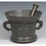 A Dutch bronze pestle and mortar, cast with birds and scrolling foliage, inscribed beneath the rim